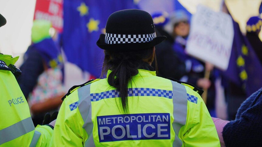 A British police officer wearing a fluoro yellow jacket.