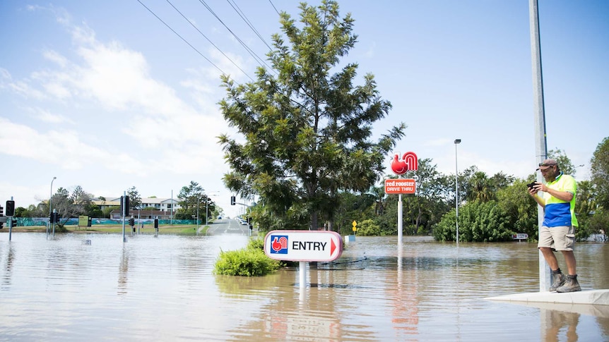 Red Rooster sign is visible as flood waters rise in Beenleigh.