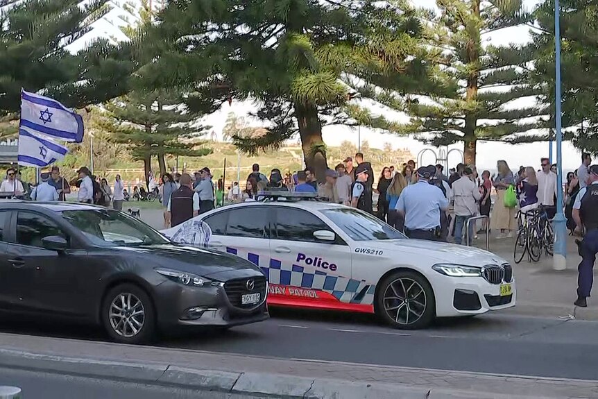 police officers at coogee and supporters of israel carrying israeli and australian flags