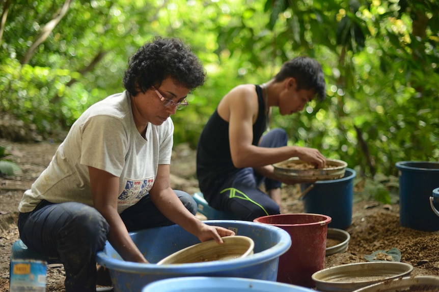 Washing dirt through sieves outside Trader's Cave.