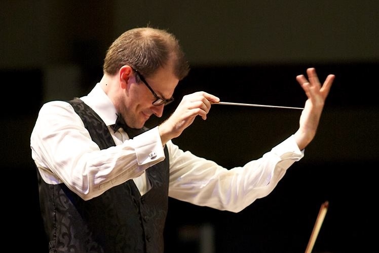 An image of Dr Ryan Williams conducting music