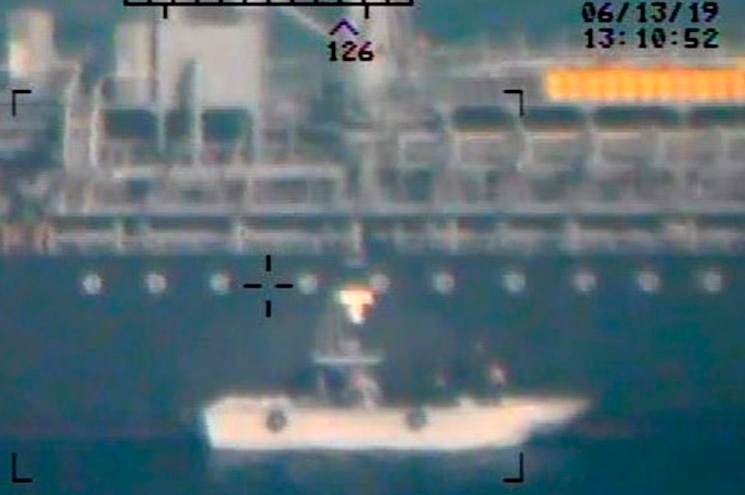 A blurred image of a boat at sea with a large vessel in the distant background