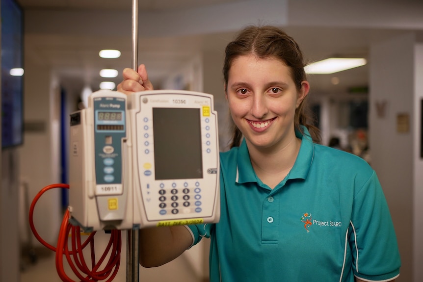 a young woman holding hospital equipment