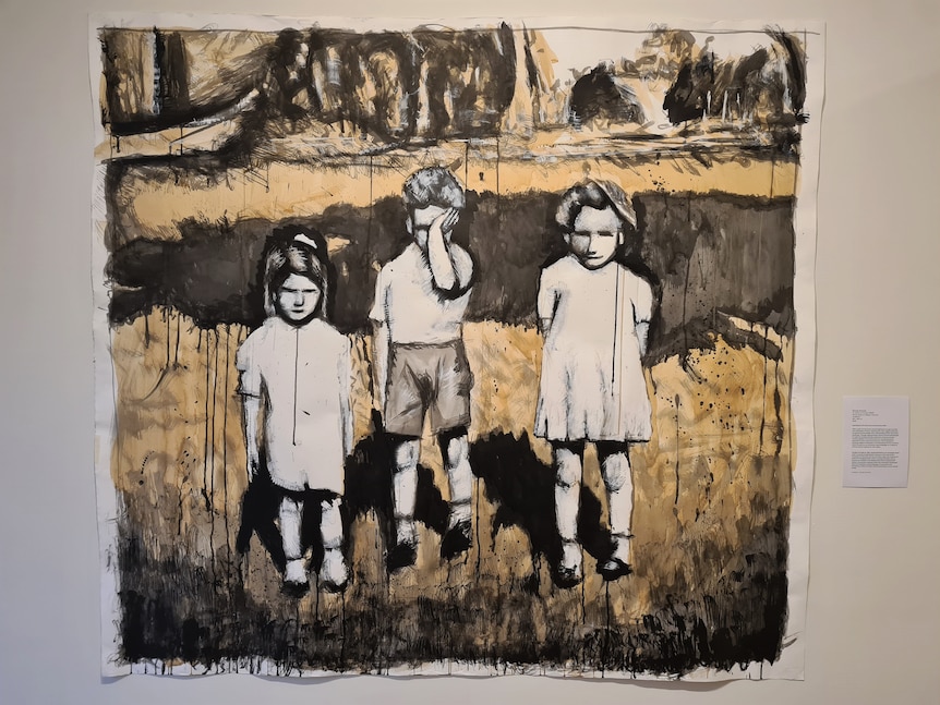 A painting of three young kids in a country setting hanging on a wall.