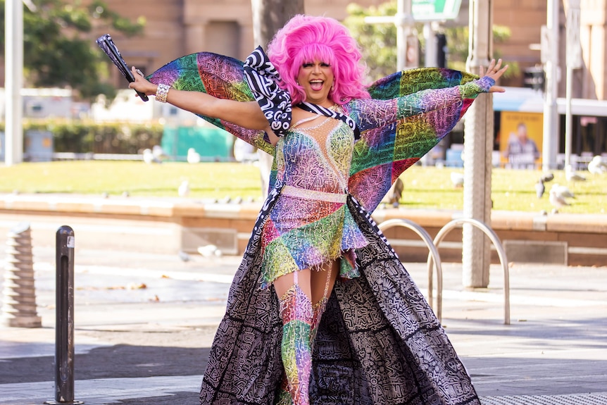 A person dressed in a colourful outfit on Oxford Street's rainbow pedestrian crossing