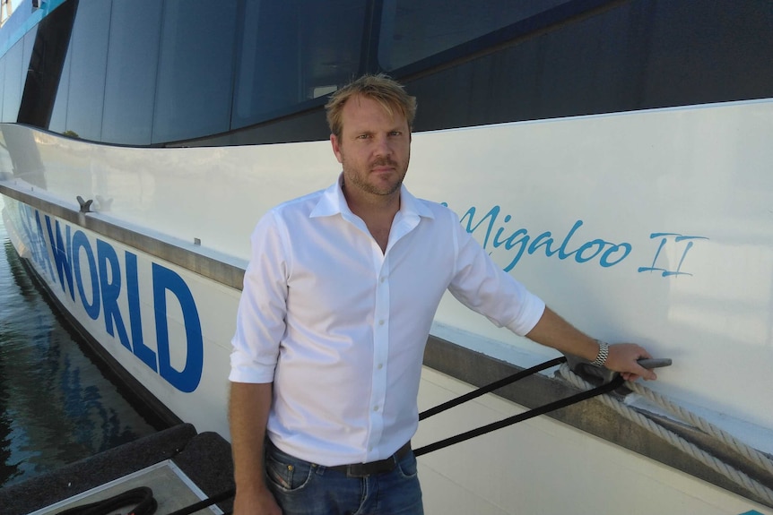 A man stands next to a boat.