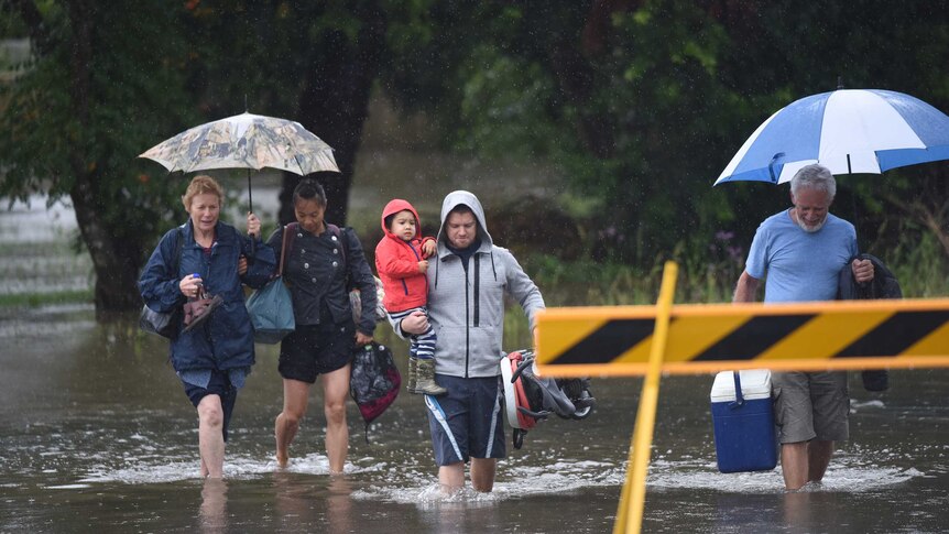 Residents walk through floodwaters in Raymond Terrace.