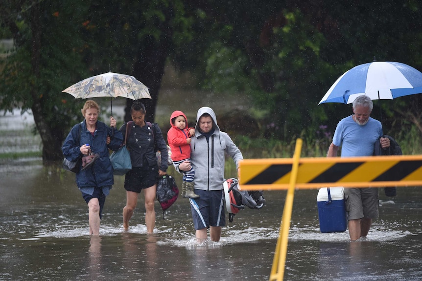 Residents walk through floodwaters in Raymond Terrace.