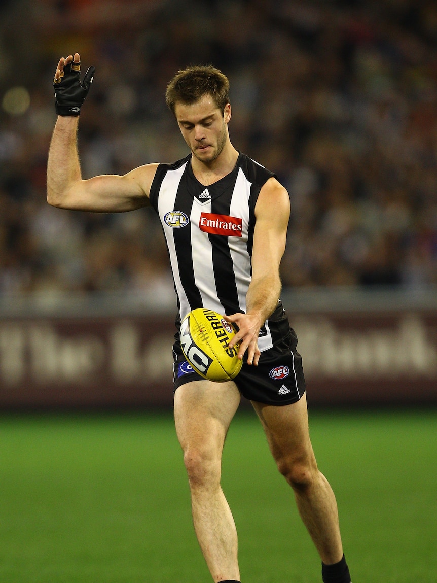 Filer of Magpies defender Alan Toovey kicking the footy