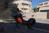 Palestinian demonstrator burns tires in clash with Israeli soldiers