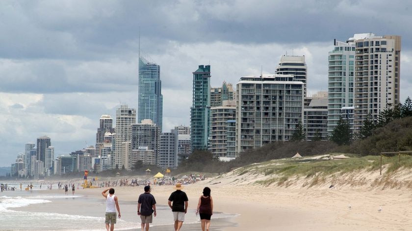 A family walk along the beach at Surfers Paradise