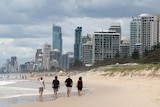 A family walk along the beach at Surfers Paradise