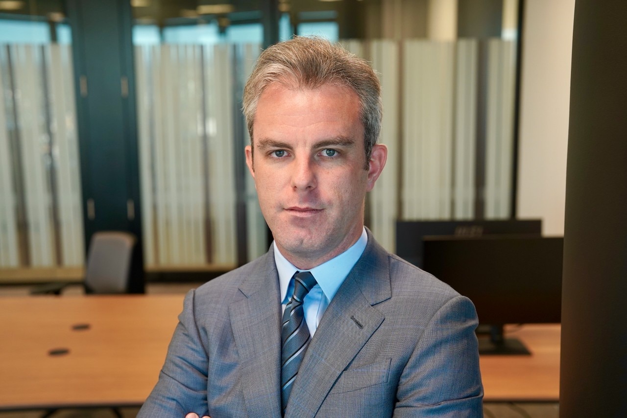 A man in a suit and tie looking into the camera.