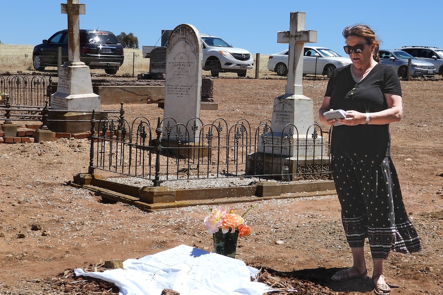 A woman standing in a cemetery.