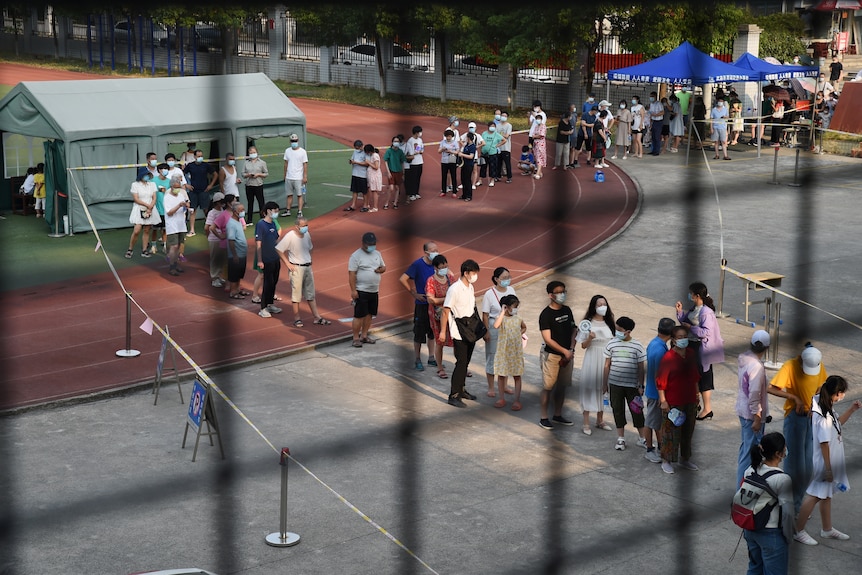 Residents stand in a long queue at a nucleic testing site in Wuhan