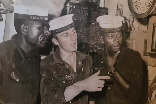 A vintage and candid photo of three sailors working together