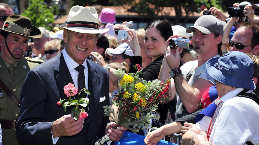 Prince Philip holds flowers and smiles as he greets the public in Perth in 2011.