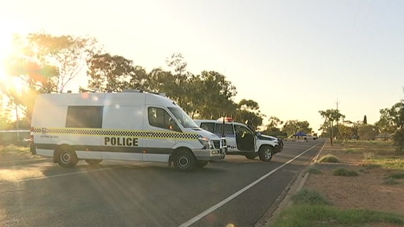 A police van and four-wheel-drive parked on a road