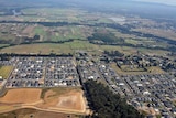 An aerial view of new housing developments on the edge of green farming areas in Sydney.