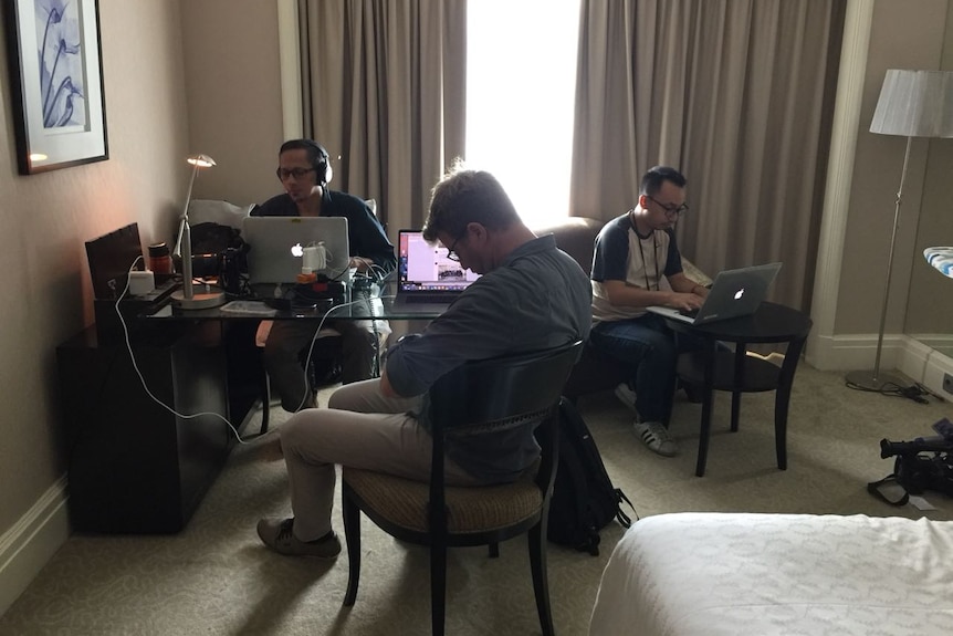 David Lipson Ari Wu and Archicco Guilianno at work on laptops in hotel room in Surabaya.