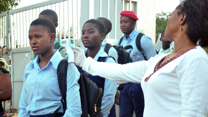 Ebola woman checks temps of schoolchildren in Abuja Nigeria