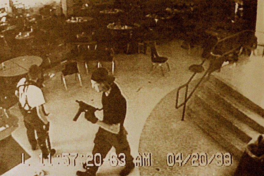 The Columbine shooters hold guns in the high school cafeteria on the day of the massacre.