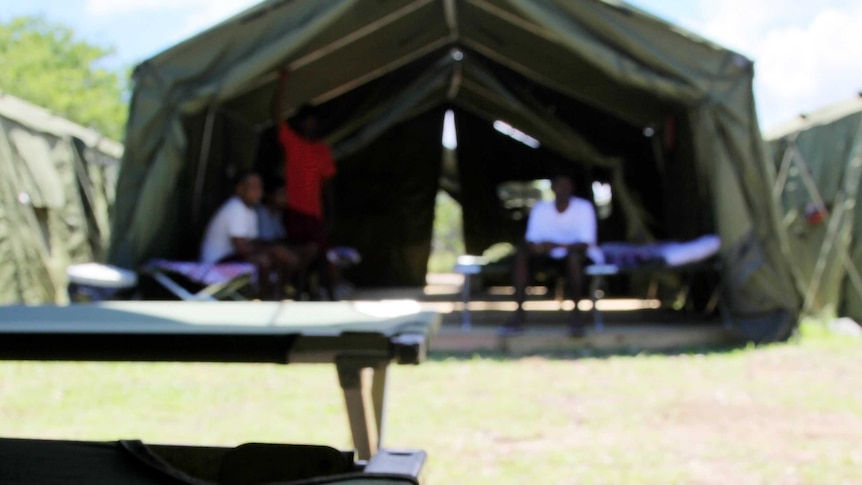 A blurry picture of unidentified people in a tent on Nauru.