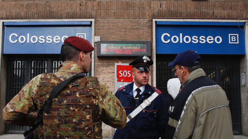 Soldiers and carabinieri direct people outside the subway station