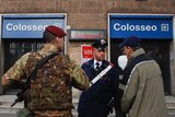 Soldiers and carabinieri direct people outside the subway station