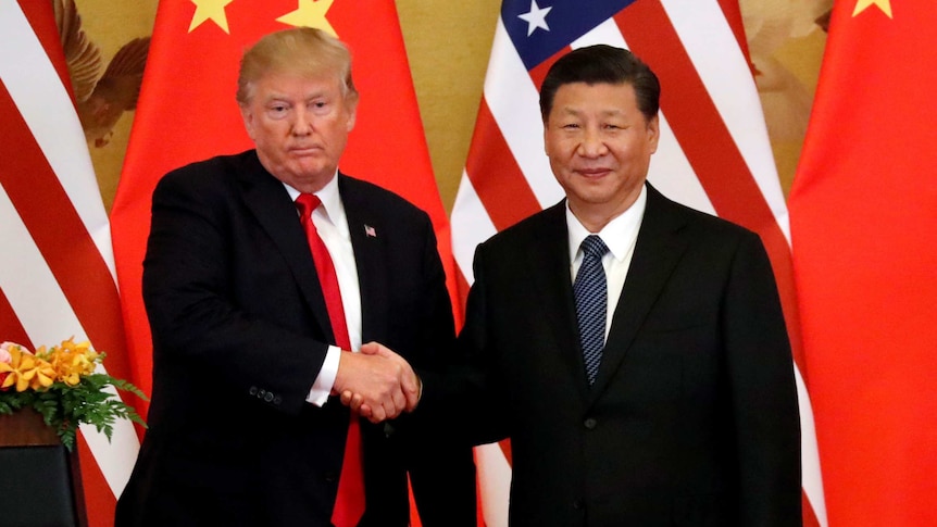 Donald Trump and Xi Jinping shake hands in front of China and US flags.
