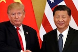 Donald Trump and Xi Jinping shake hands in front of China and US flags.
