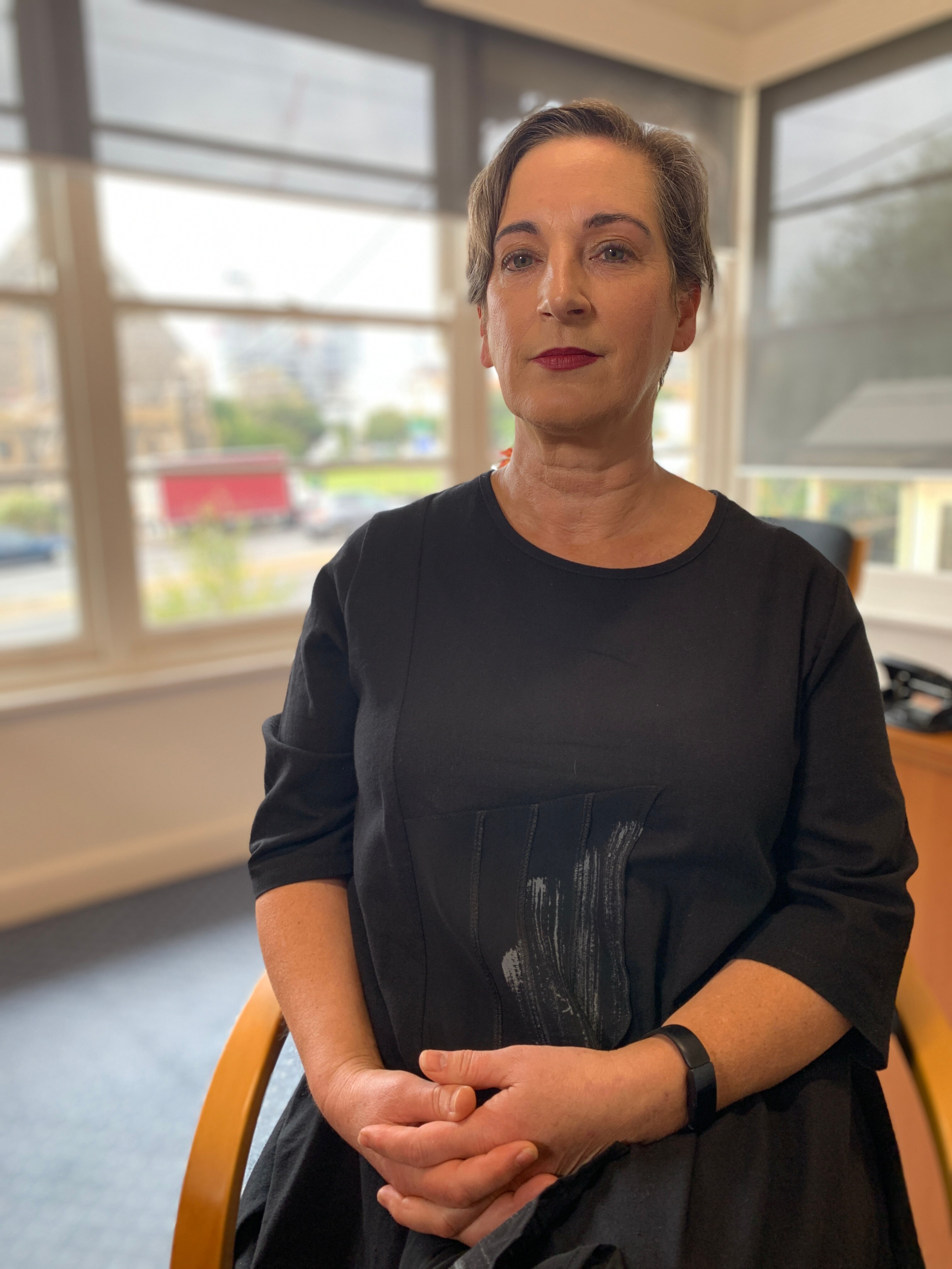 A woman sitting down in a black dress