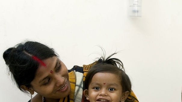 Indian girl Lakshmi sits with her mother Poonam