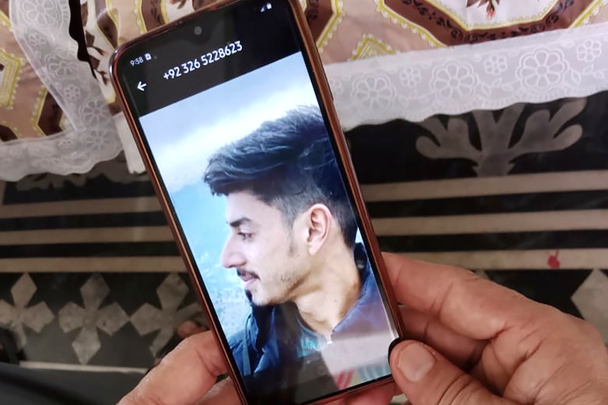 A phone screen showing a photo of a young middle eastern man 