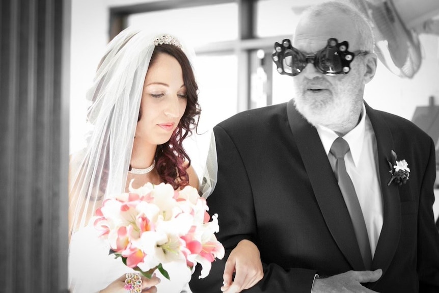 A bride and her father, wearing wacky sunglasses.