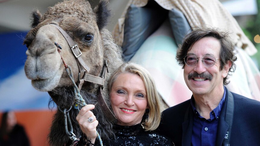 Robyn Davidson and photographer Rick Smolan with a camel at the premiere of Tracks