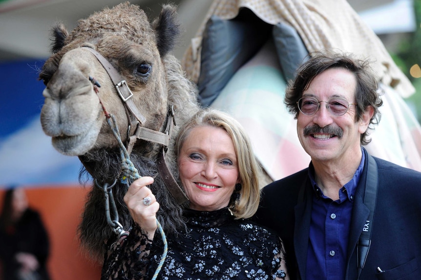 Robyn Davidson and photographer Rick Smolan with a camel at the premiere of Tracks