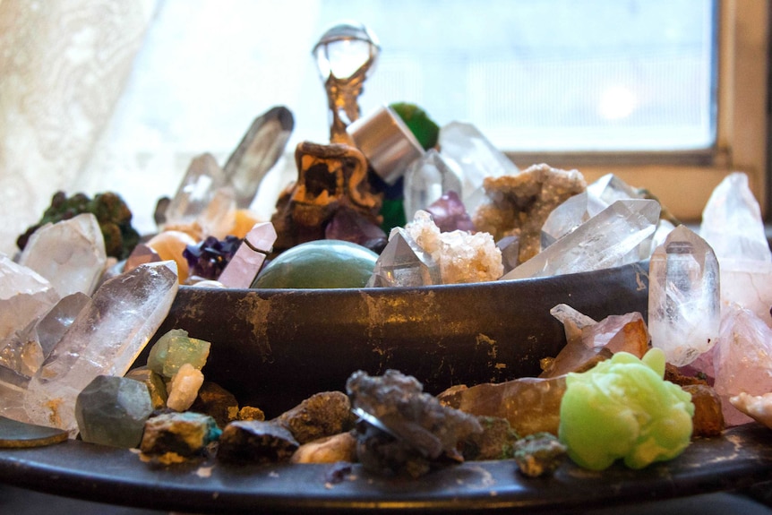 Collection of crystals in bowl and on plate, sitting in front of window.
