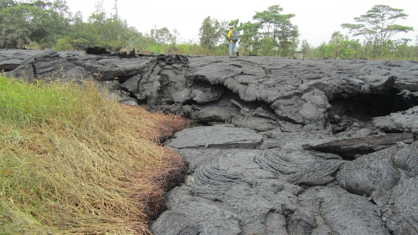 A geologist walks on surface of lava flow from Hawaii's Kilauea volcano