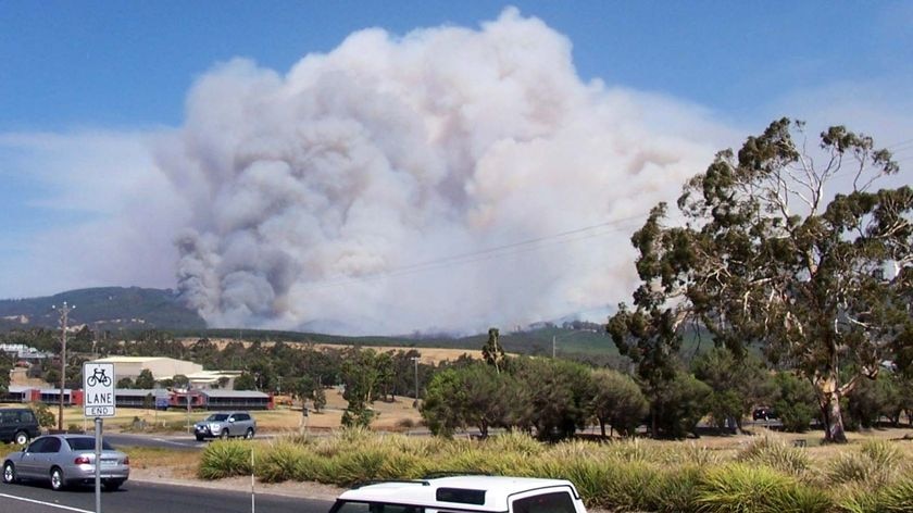 Vehicles make their way through the town of Churchill as backburning takes place