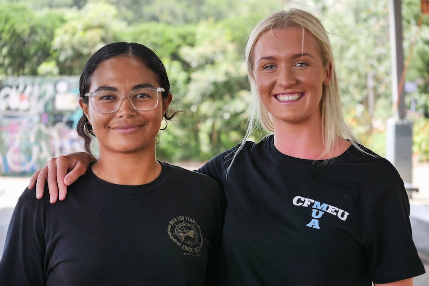 Two young women standing side by side. 