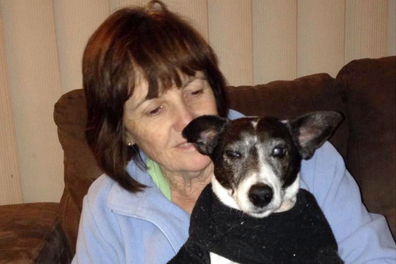 Sue Lopicich sitting on a couch holding a dog