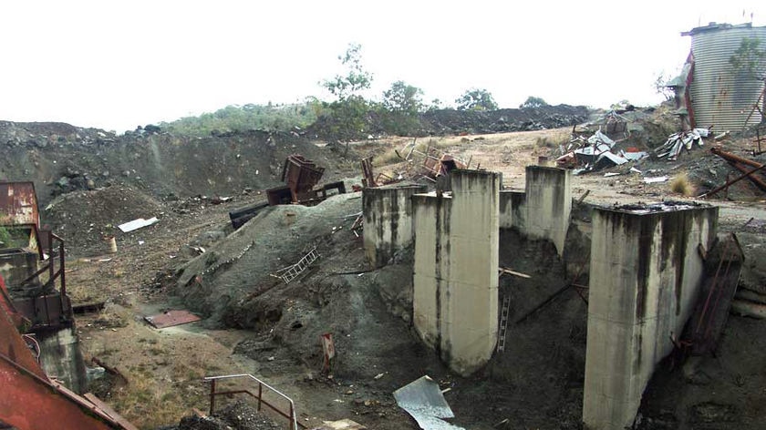 Piles of asbestos and rusting equipment at an abandoned mine