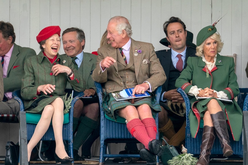 Princess Anne and Prince Charles laugh to each other next to Camilla as they sit at the Fife Memorial Park in Braemar Scotland