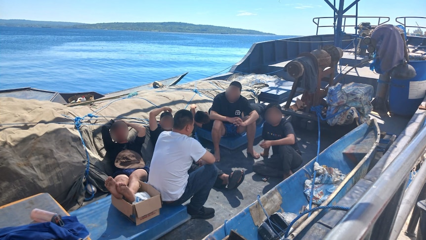 A group of Chinese men sitting on the boat. 