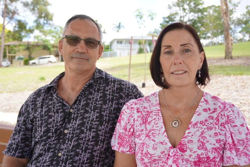 A man and woman sit at a park bench.