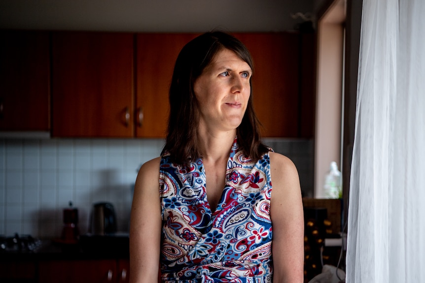 Jennelle Schroder gazes out a window with a thoughtful expression on her face.