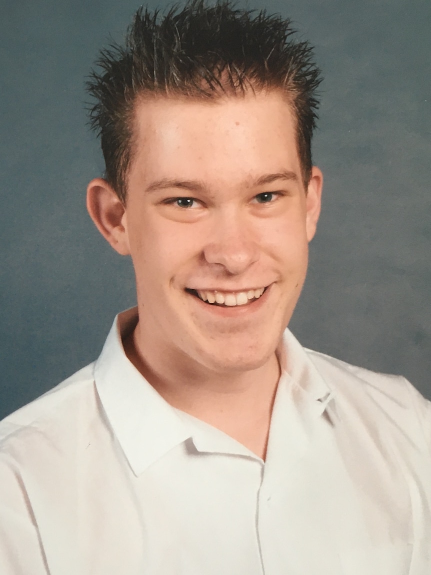 A young teen smiles for a school photo.