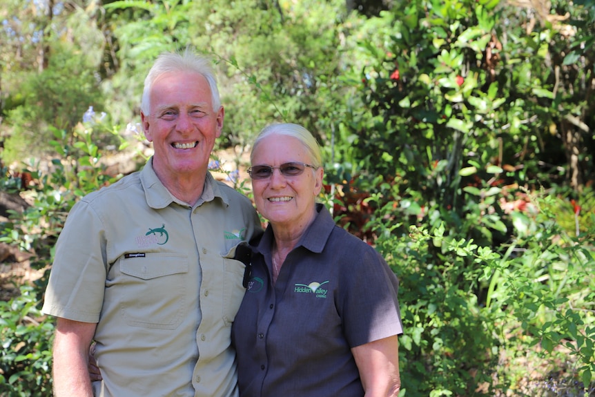 A man with his arms around a women in a green garden