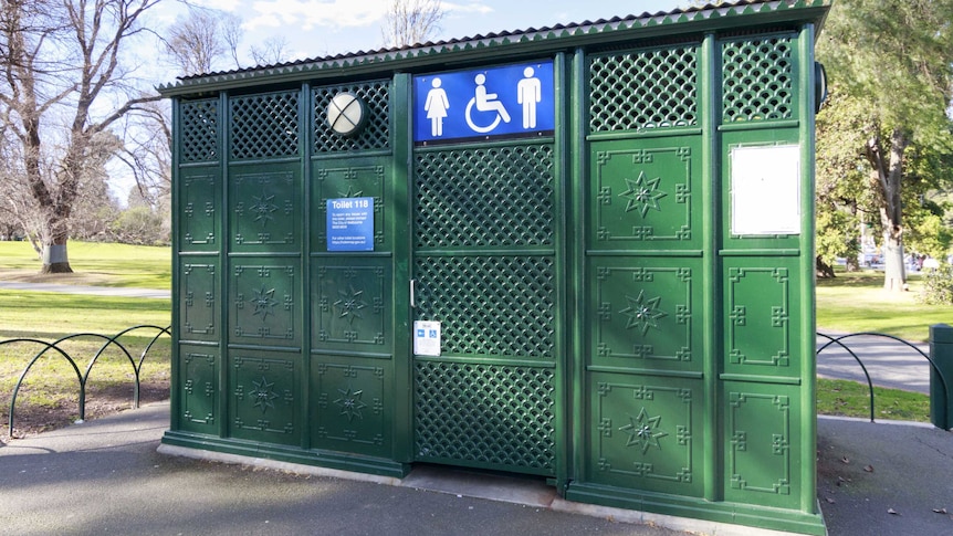 A Victorian style public toilet: a freestanding box made of pressed iron, painted green, a blue and white toilet symbol on front